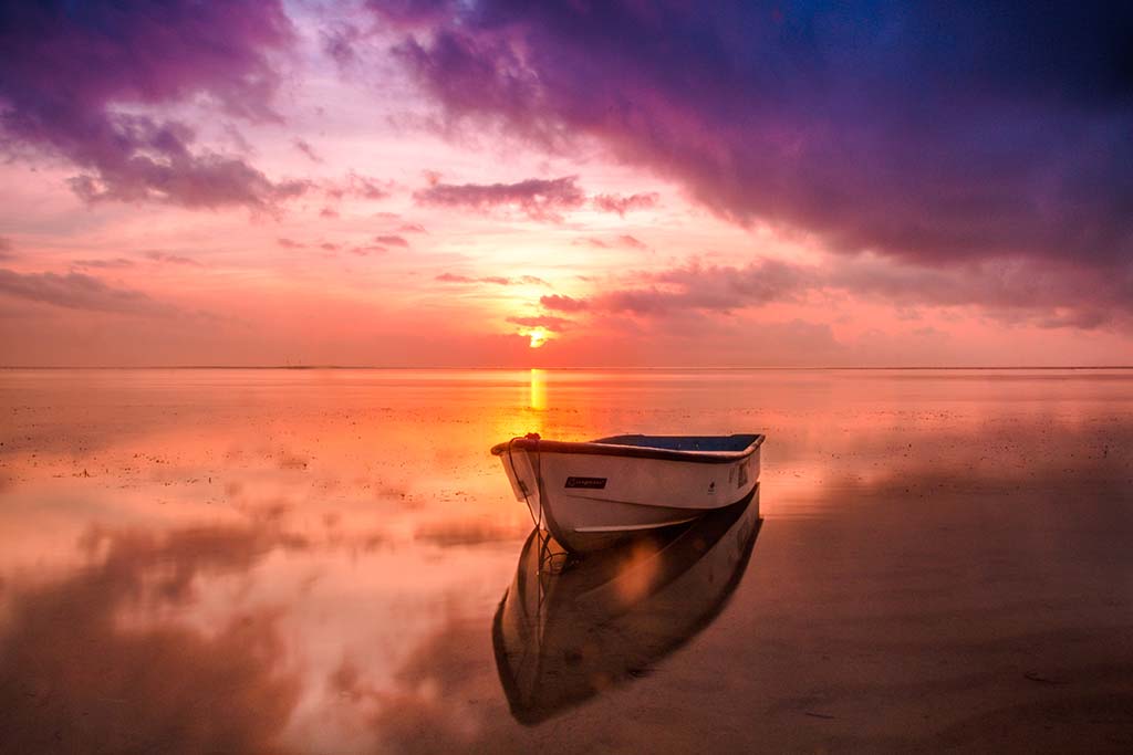Image of empty boat on a lake at sunrise